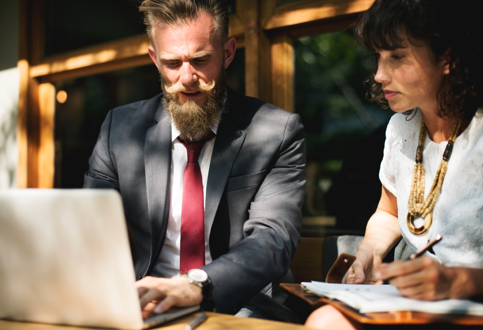 Researcher observing employee working on laptop